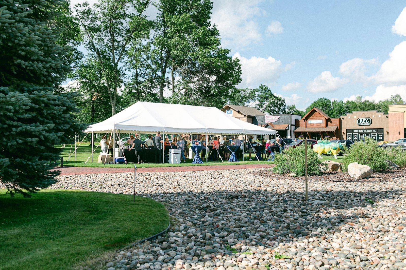 White frame tent sheltering guests at an outdoor community event