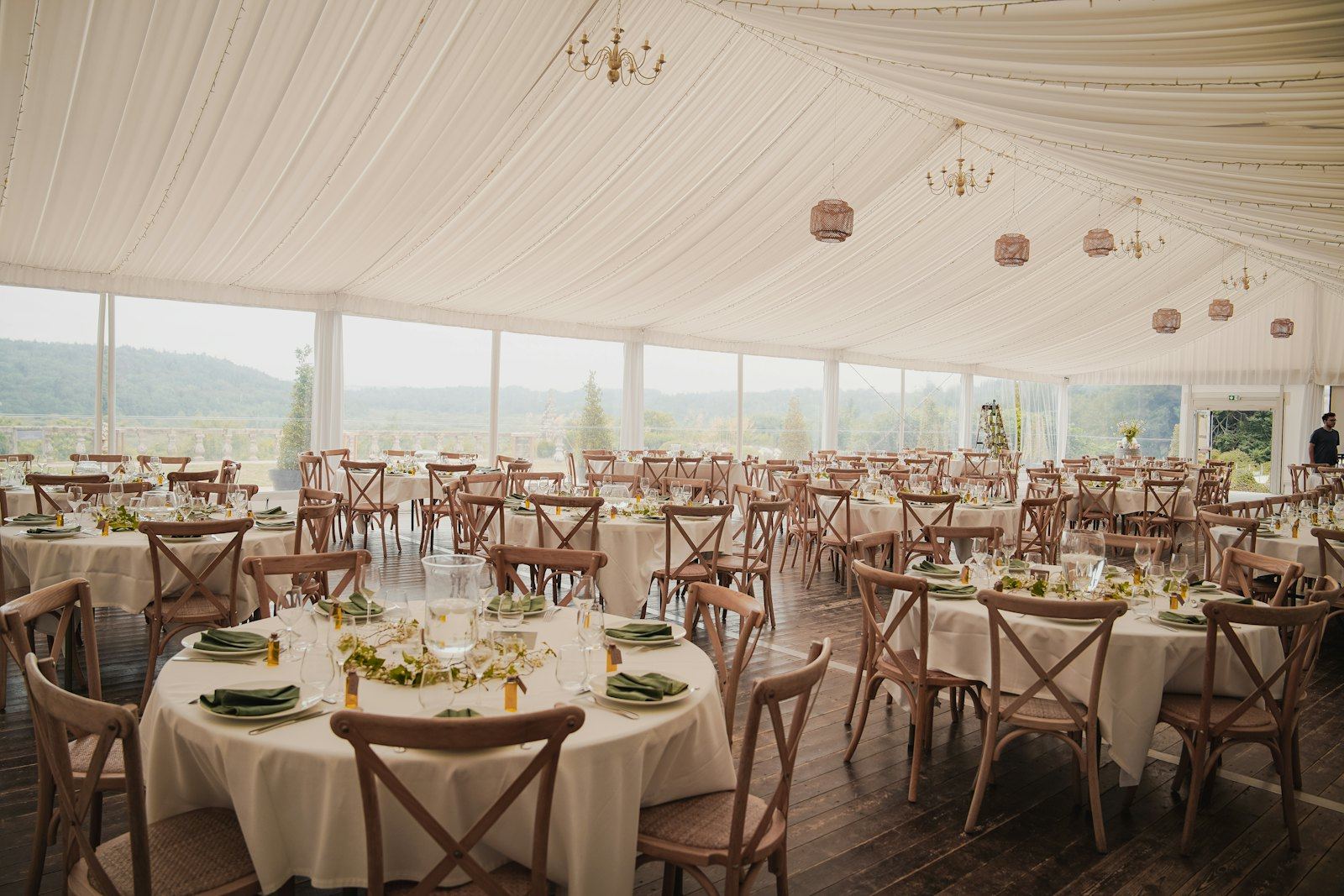 Tented reception with round tables and cross-back chairs