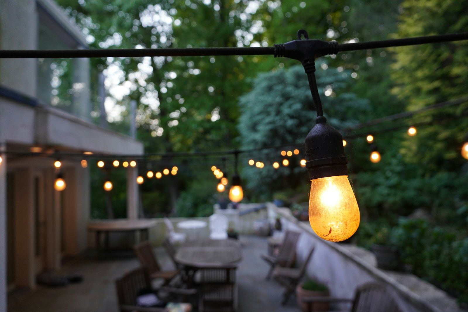 String lights glowing over an evening patio party