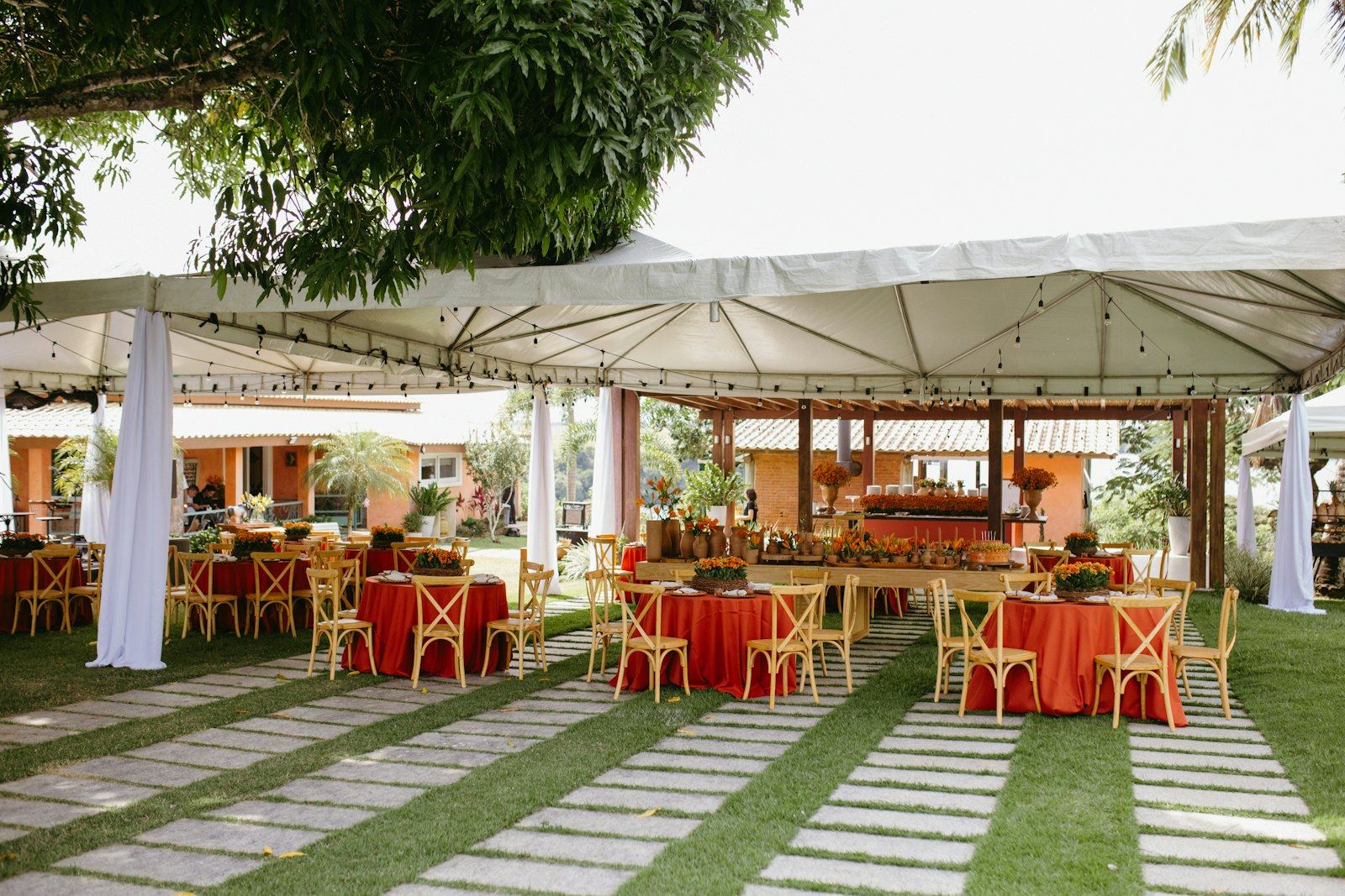 Garden event under a white tent with round tables